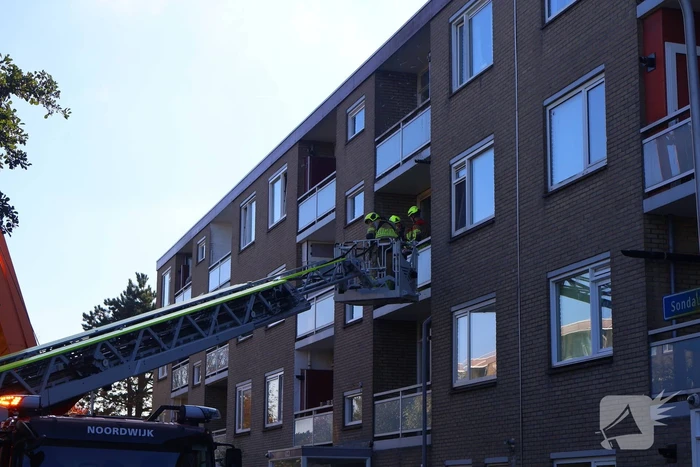 Persoon door hijskraan uit flatwoning getakeld