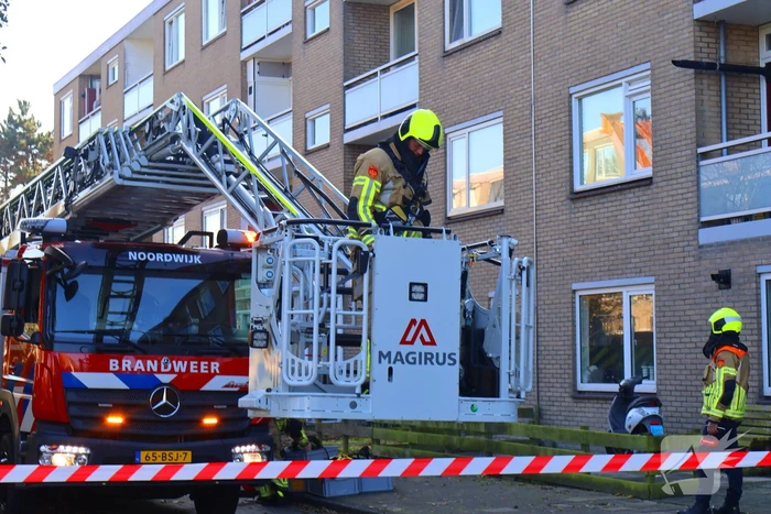 Persoon door hijskraan uit flatwoning getakeld