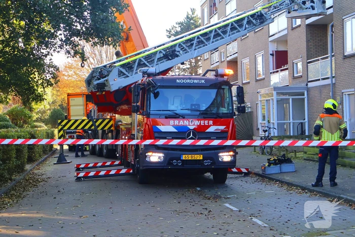 Persoon door hijskraan uit flatwoning getakeld