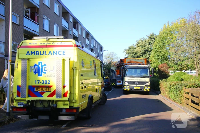 Persoon door hijskraan uit flatwoning getakeld