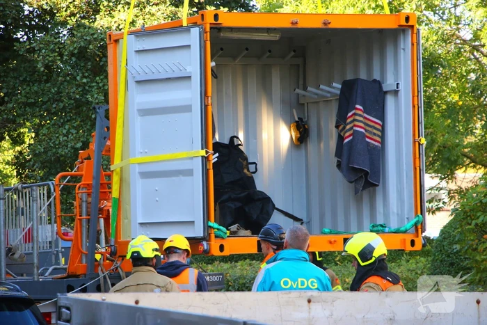 Persoon door hijskraan uit flatwoning getakeld