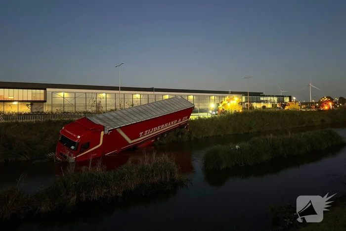 Te water geraakte vrachtwagen geborgen door grote hijskranen