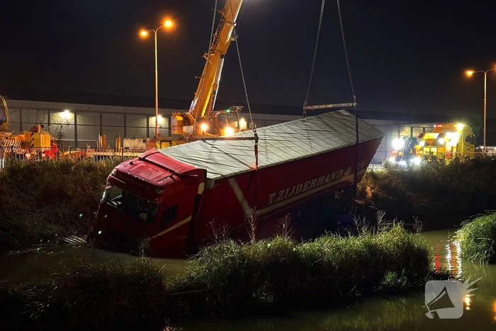 Te water geraakte vrachtwagen geborgen door grote hijskranen