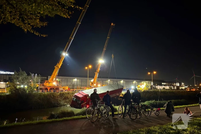 Te water geraakte vrachtwagen geborgen door grote hijskranen