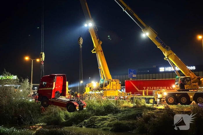 Te water geraakte vrachtwagen geborgen door grote hijskranen