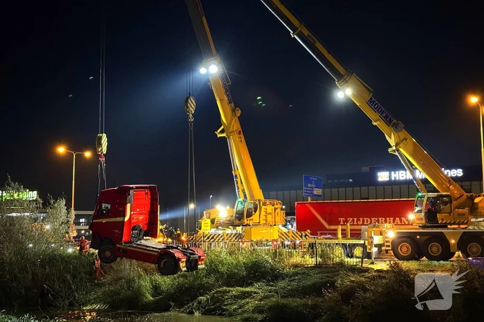 Te water geraakte vrachtwagen geborgen door grote hijskranen