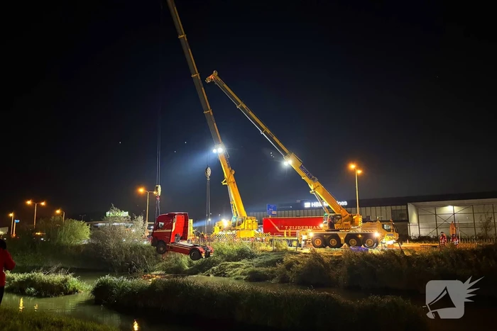 Te water geraakte vrachtwagen geborgen door grote hijskranen