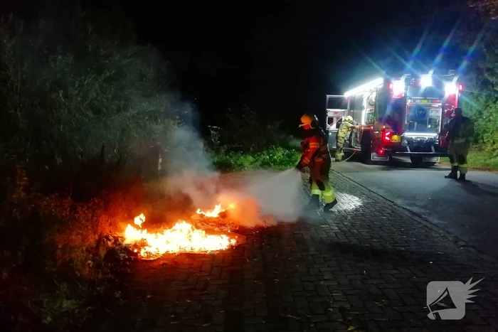 Brandweer dooft in brand gestoken afval