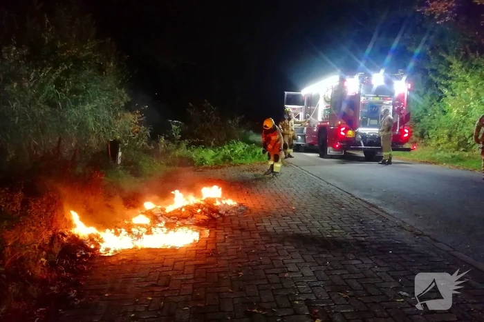 Brandweer dooft in brand gestoken afval