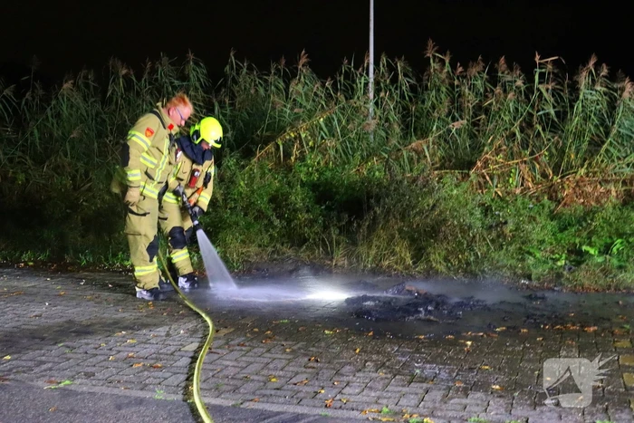 Brandweer dooft in brand gestoken afval