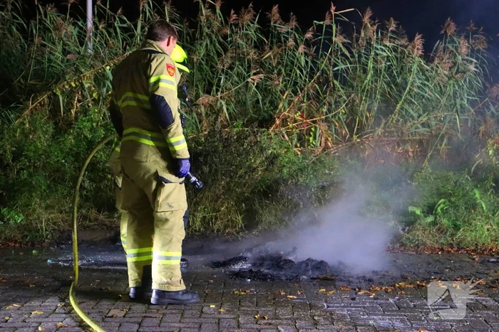 Brandweer dooft in brand gestoken afval