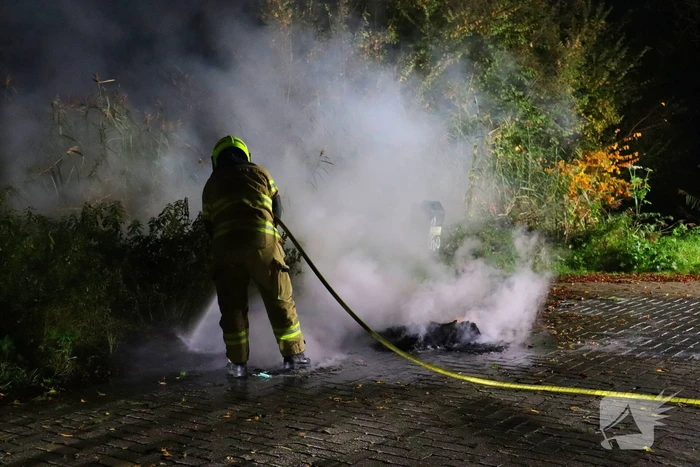 Brandweer dooft in brand gestoken afval
