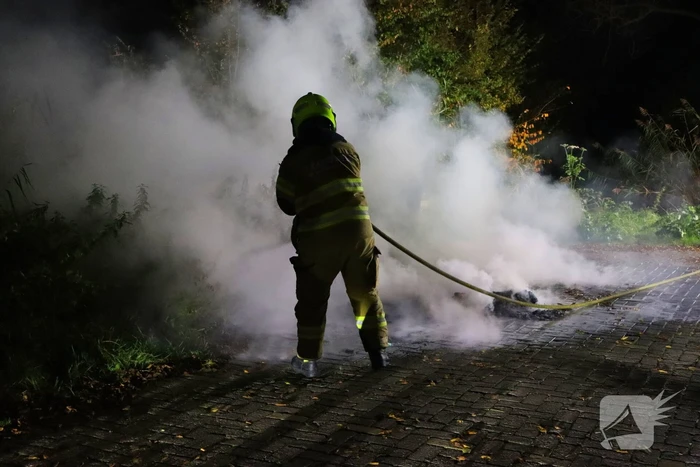 Brandweer dooft in brand gestoken afval