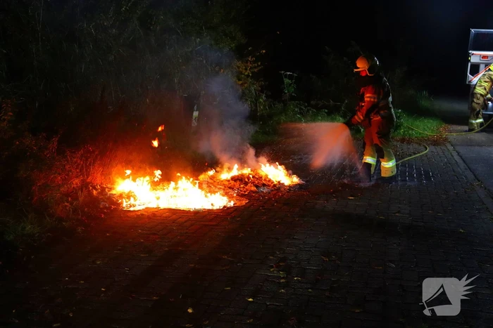 Brandweer dooft in brand gestoken afval