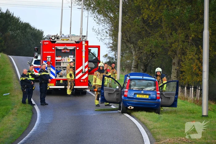 Personenauto vat vlam onder motorkap