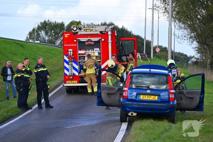 Personenauto vat vlam onder motorkap