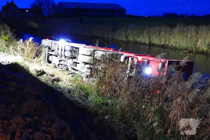 Vrachtwagen op zijn kant in de sloot