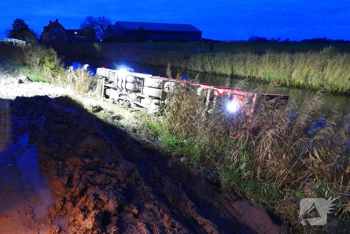 Vrachtwagen op zijn kant in de sloot