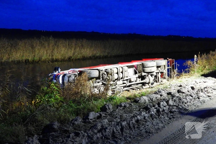 Vrachtwagen op zijn kant in de sloot
