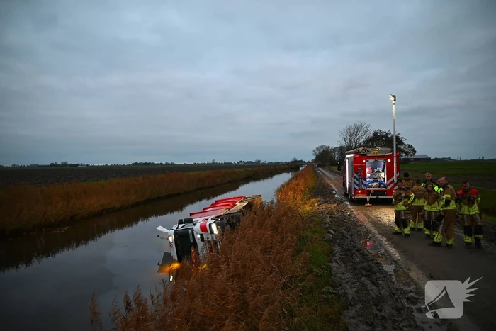 Vrachtwagen op zijn kant in de sloot