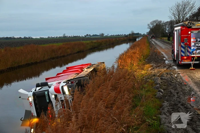 Vrachtwagen op zijn kant in de sloot
