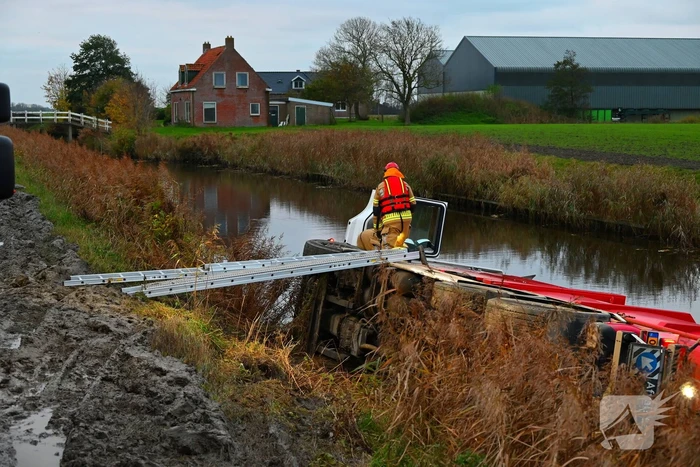 Vrachtwagen op zijn kant in de sloot