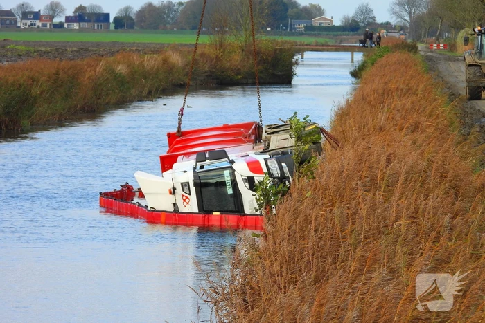Vrachtwagen op zijn kant in de sloot