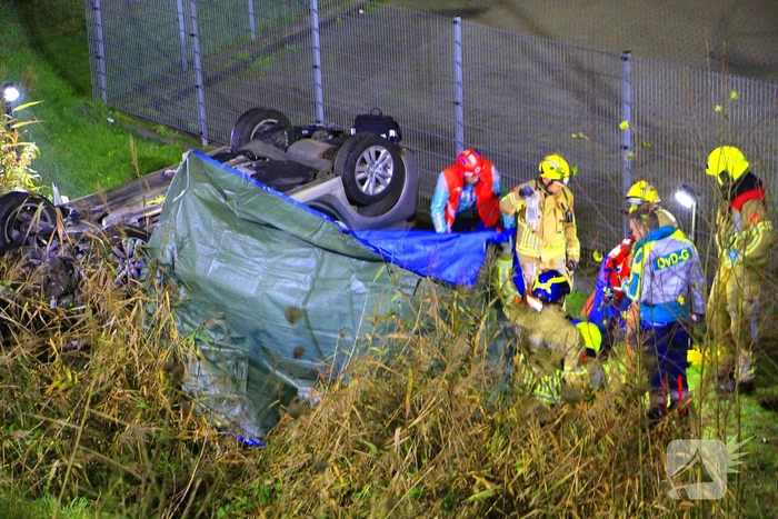 Auto rijdt van talud en belandt op de kop, inzittende gereanimeerd