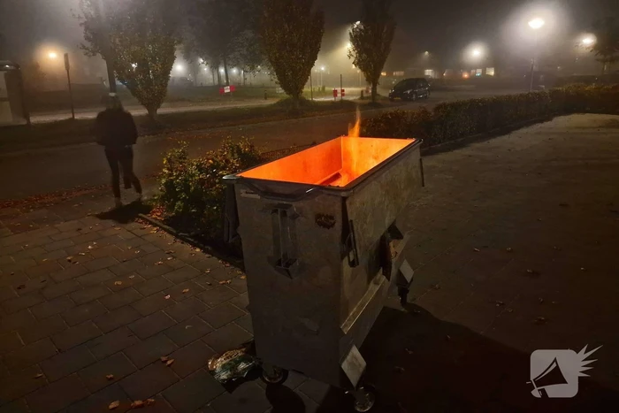 Brandweer blust brand in afvalcontainer