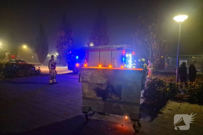 Brandweer blust brand in afvalcontainer