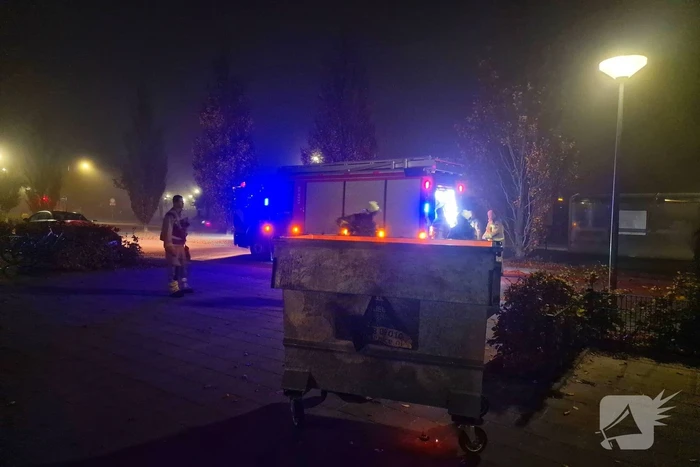 Brandweer blust brand in afvalcontainer