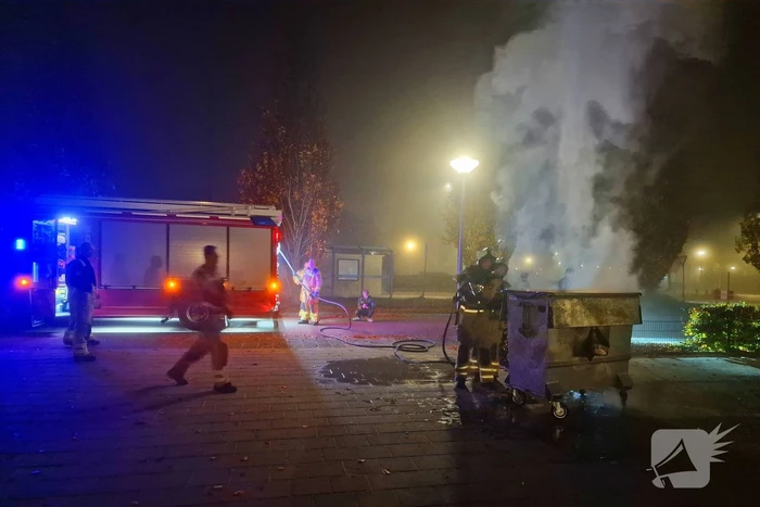 Brandweer blust brand in afvalcontainer