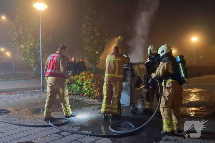 Brandweer blust brand in afvalcontainer