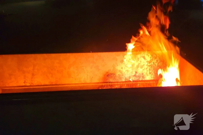 Brandweer blust brand in afvalcontainer