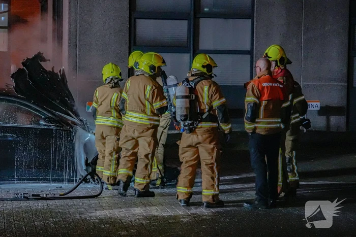 Brandweer blust brandende auto
