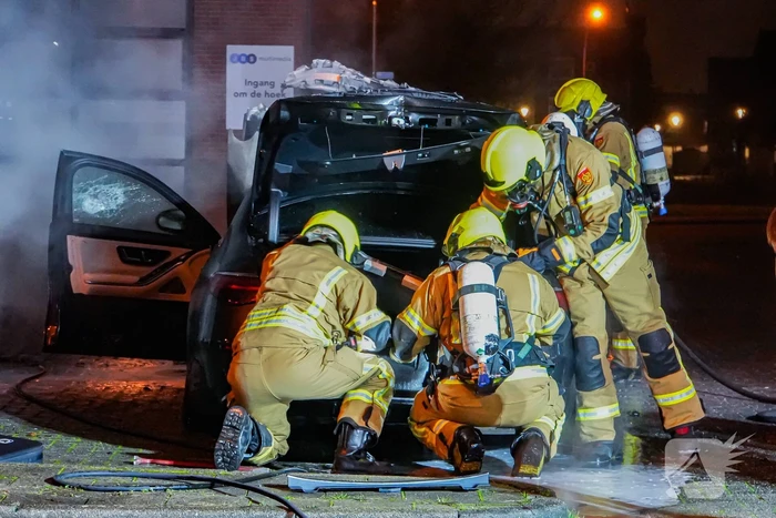 Brandweer blust brandende auto