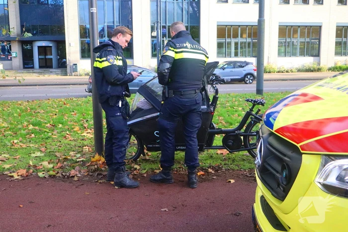 Persoon op bakfiets glijdt onderuit door bladeren op fietspad