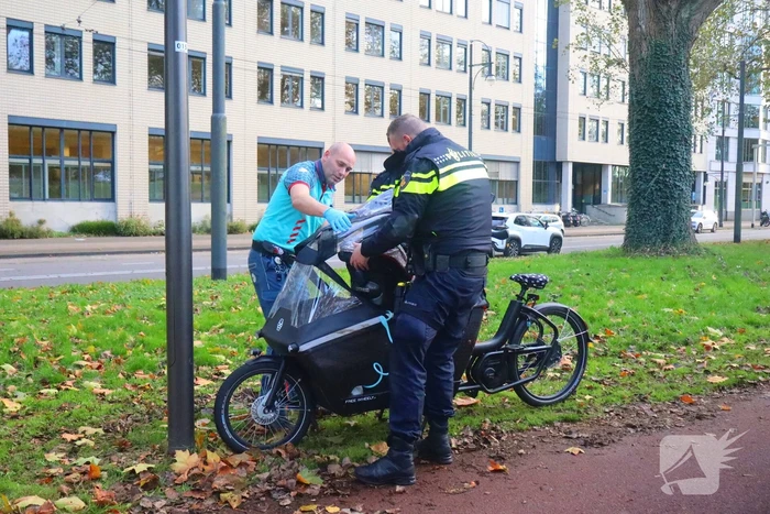 Persoon op bakfiets glijdt onderuit door bladeren op fietspad