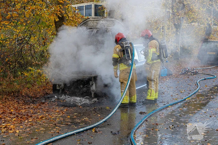 Brandweer blust brand in personenauto