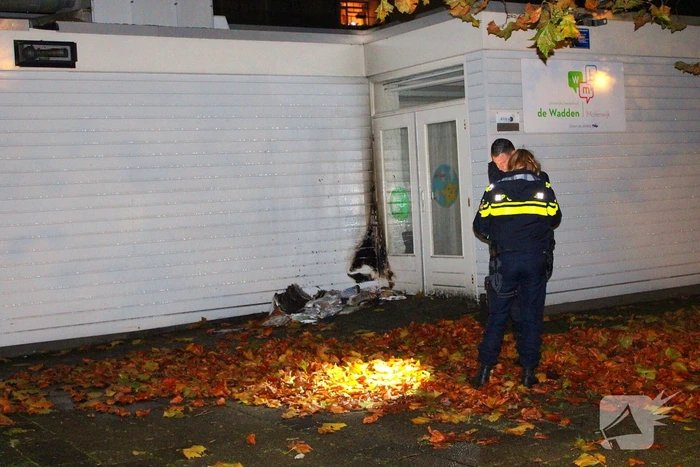 Brand in stapel reclamefolders tegen schoolgebouw