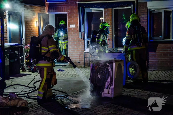 Brandweer blust brandende wasmachine
