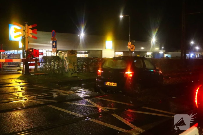 Auto belandt gedeeltelijk op spoor bij overweg