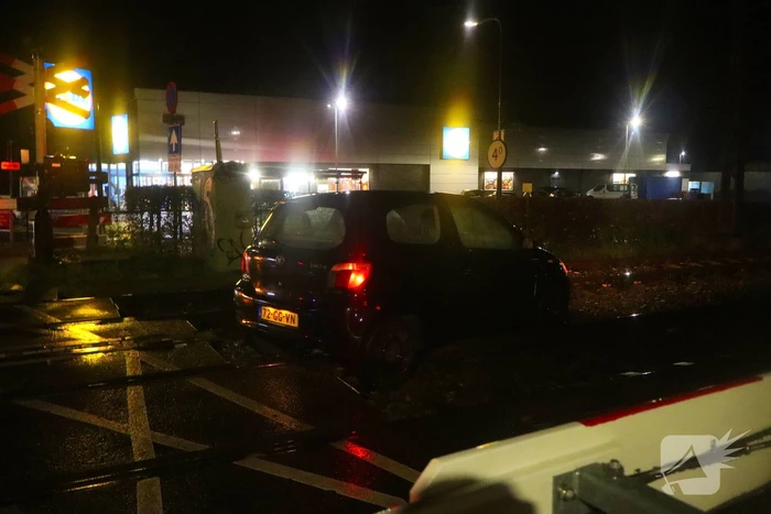 Auto belandt gedeeltelijk op spoor bij overweg