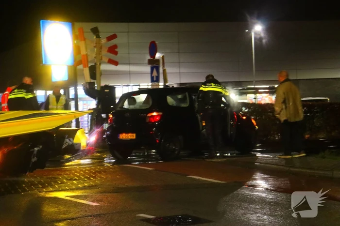 Auto belandt gedeeltelijk op spoor bij overweg