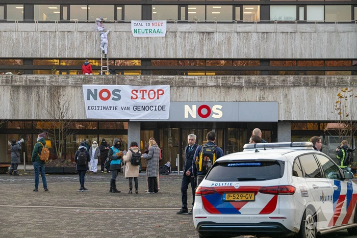 Demonstranten klimmen op het dak van NOS-gebouw