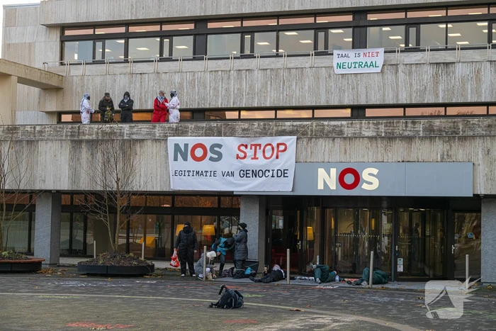 Demonstranten klimmen op het dak van NOS-gebouw