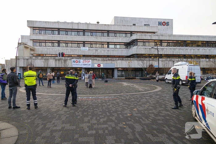 Demonstranten klimmen op het dak van NOS-gebouw