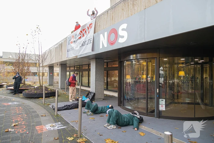 Demonstranten klimmen op het dak van NOS-gebouw