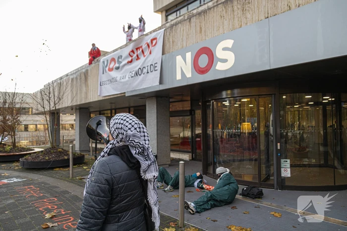 Demonstranten klimmen op het dak van NOS-gebouw