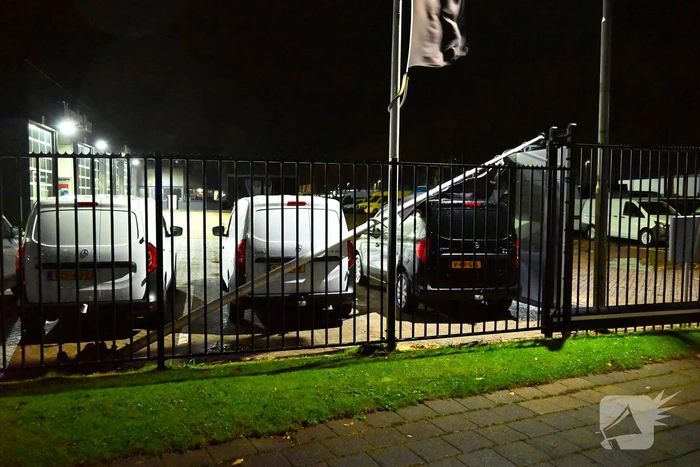 Vlaggenmast belandt op auto door sterke wind